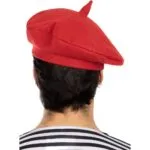 כובע ברט אדום בסגנון צרפתי על ראש של גבר בחולצת פסים, מבט מאחור