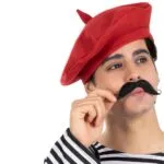 כובע ברט אדום על ראש של גבר עם שפם שחור בחולצת פסים, בסגנון צרפתי